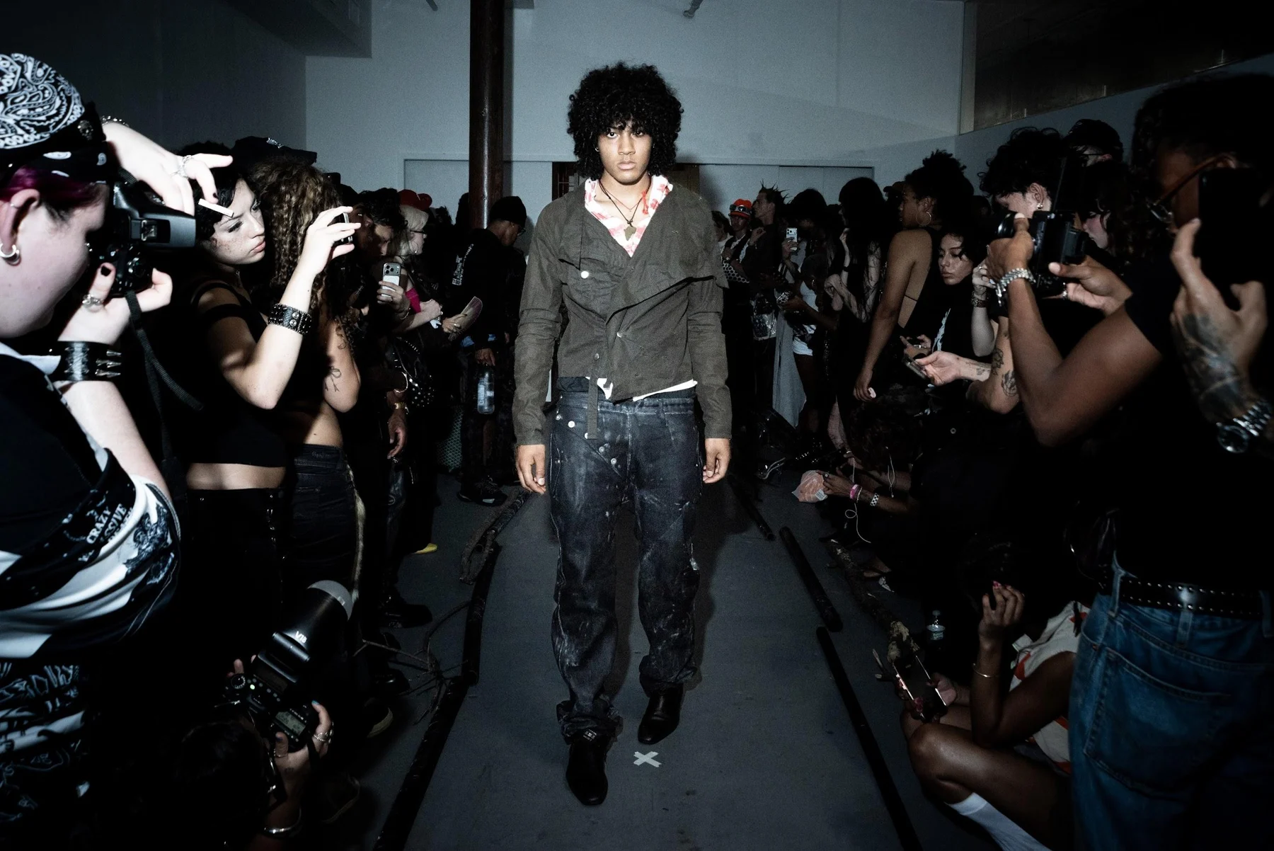 Slouch Military Jacket / “Prison” Striped Hoodie / Curved Button Fly Denim worn together on the runway